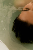 Close-up of a man relaxing with eyes closed in a calming bath, symbolizing skincare hydration and stress relief.