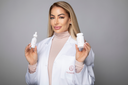 Audrose® founder, Justine Nichole, in a white lab coat, holding the brand’s breakthrough products, sharing her personal 2-step ritual for restoring hydration, protection, and calming benefits to sensitive skin.